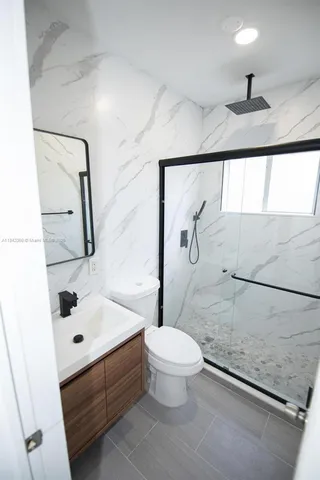 a bathroom with a sink a toilet and shower