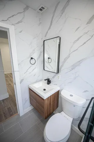 a bathroom with a toilet sink and mirror