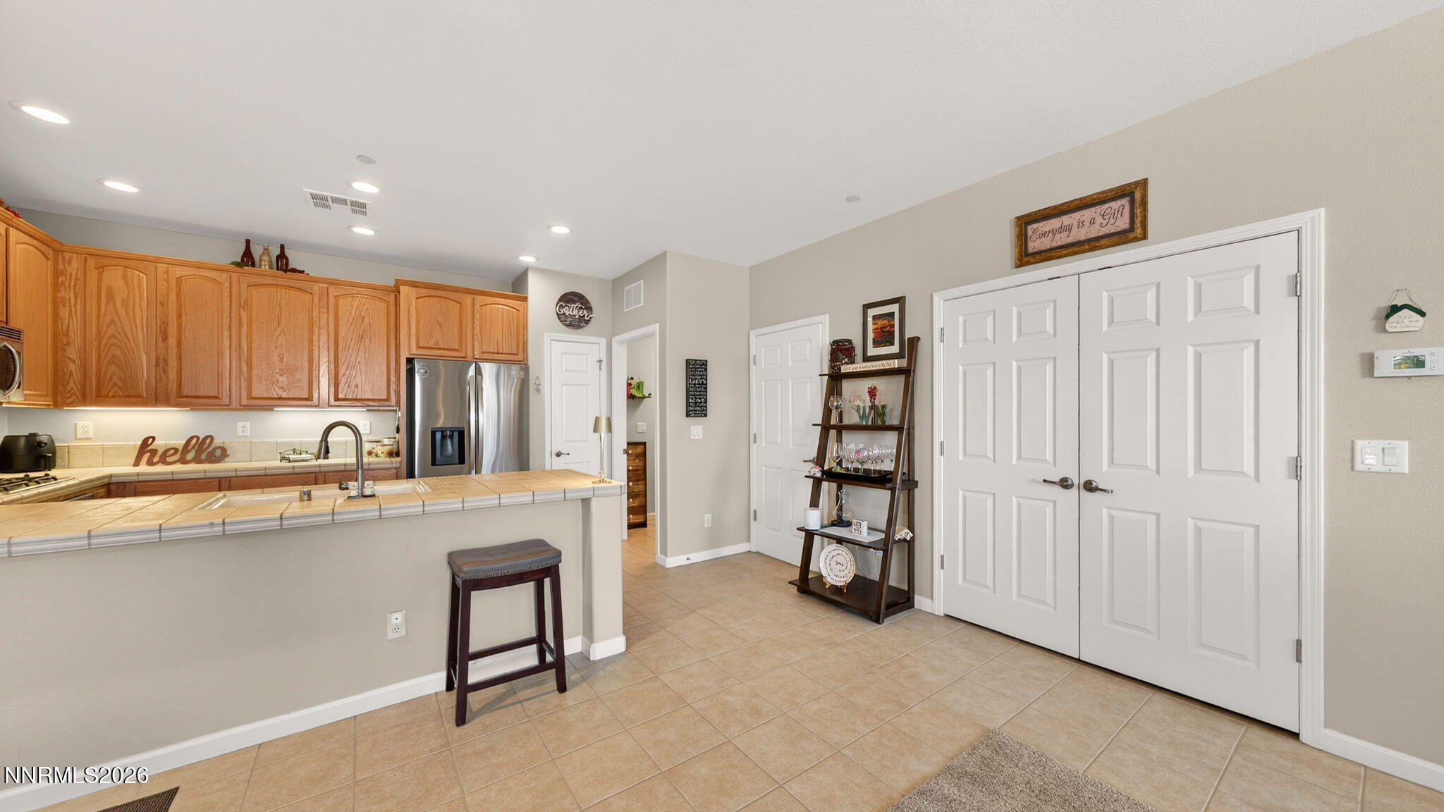 1750 Wind Ranch Road, Unit B Reno, NV 89521 - Photo 13 of 42 a large white kitchen with stainless steel appliances granite countertop a refrigerator and a sink