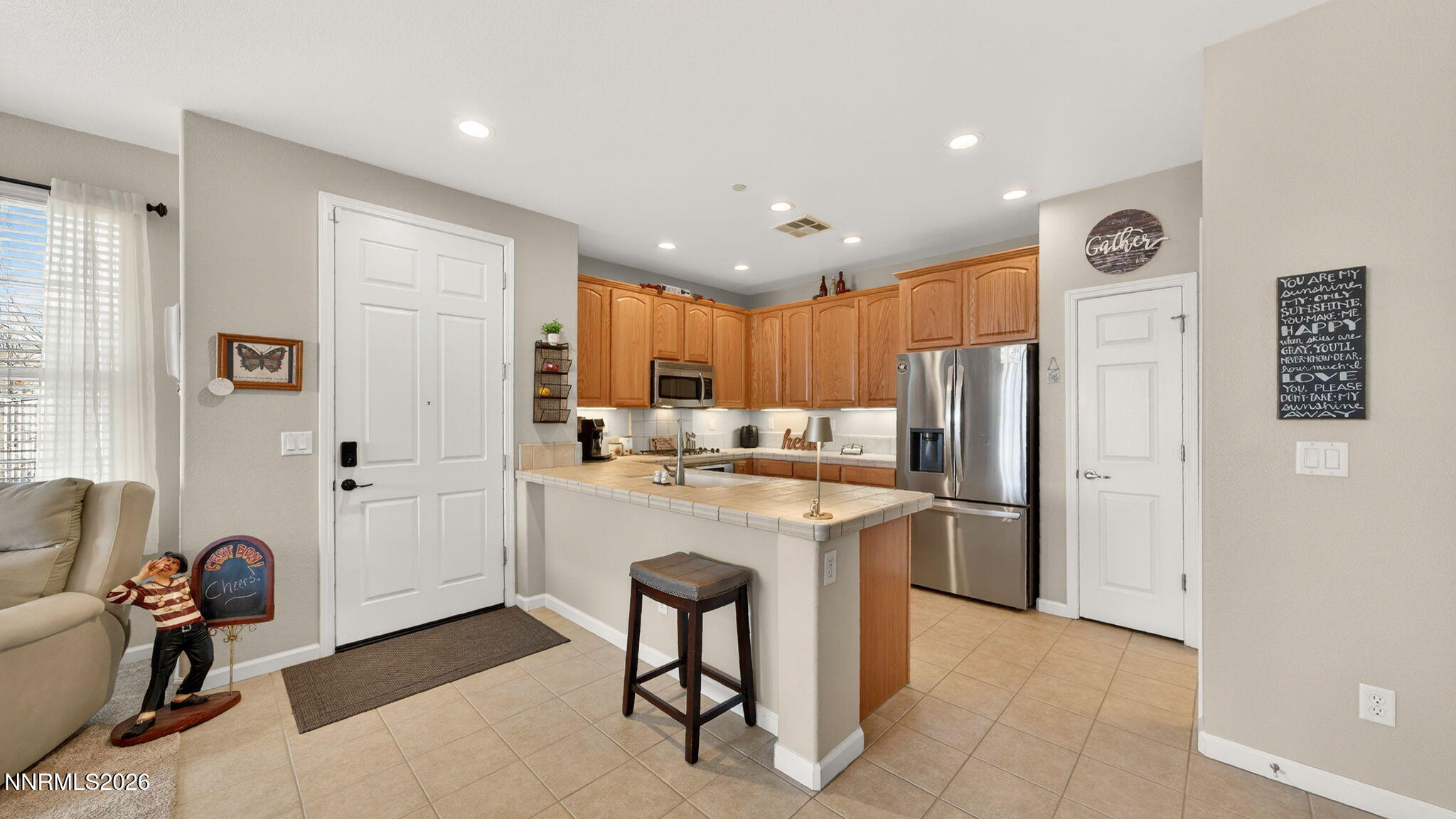 1750 Wind Ranch Road, Unit B Reno, NV 89521 - Photo 14 of 42 a kitchen with stainless steel appliances kitchen island granite countertop a refrigerator and a sink