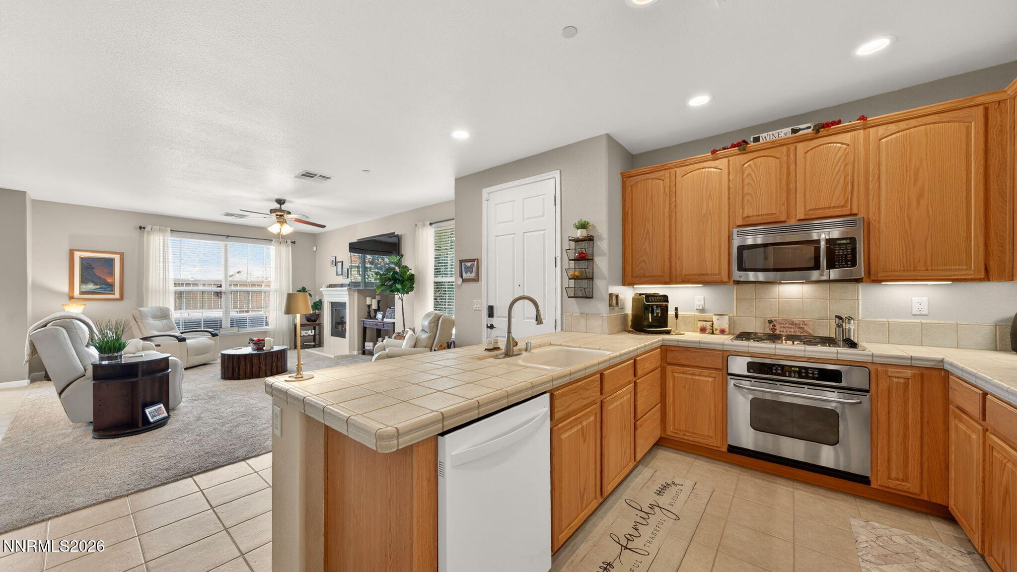 1750 Wind Ranch Road, Unit B Reno, NV 89521 - Photo 15 of 42 a kitchen with a stove top oven a sink dishwasher and wooden cabinets