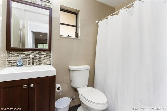 a bathroom with a toilet a sink and a mirror