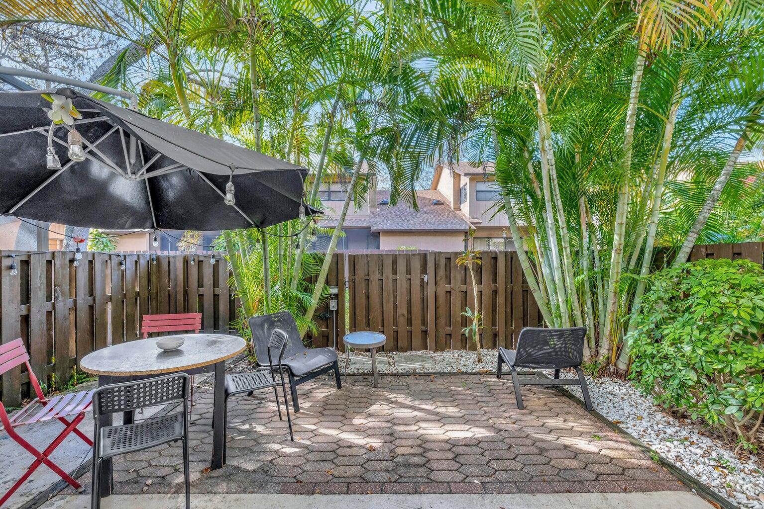 7610 Northwest 79th Avenue, Unit I5 Fort Lauderdale, FL 33321 - Photo 15 of 22 a backyard of a house with table and chairs