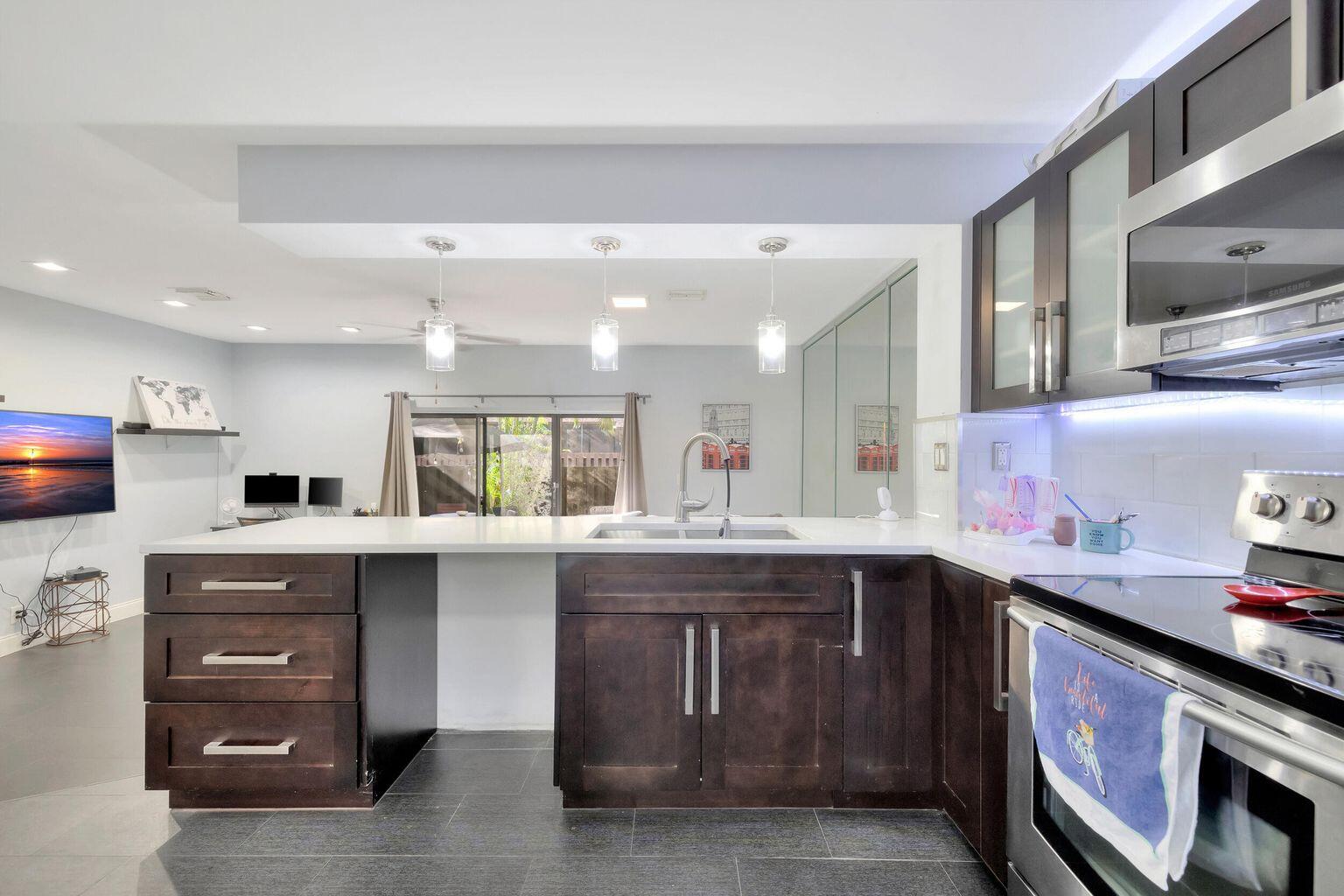 7610 Northwest 79th Avenue, Unit I5 Fort Lauderdale, FL 33321 - Photo 4 of 22 a kitchen with a sink stove and cabinets