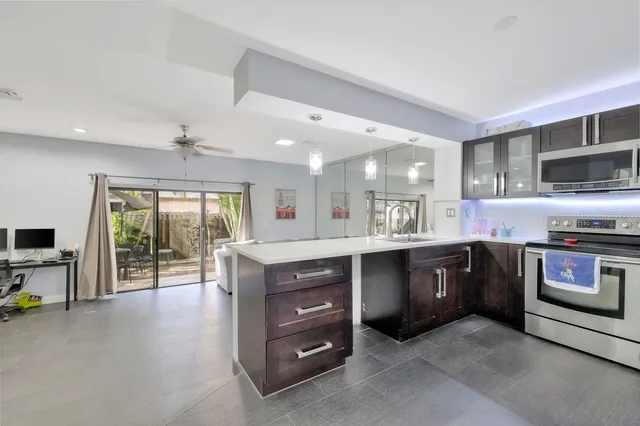 a kitchen with stainless steel appliances granite countertop a stove a sink and a microwave