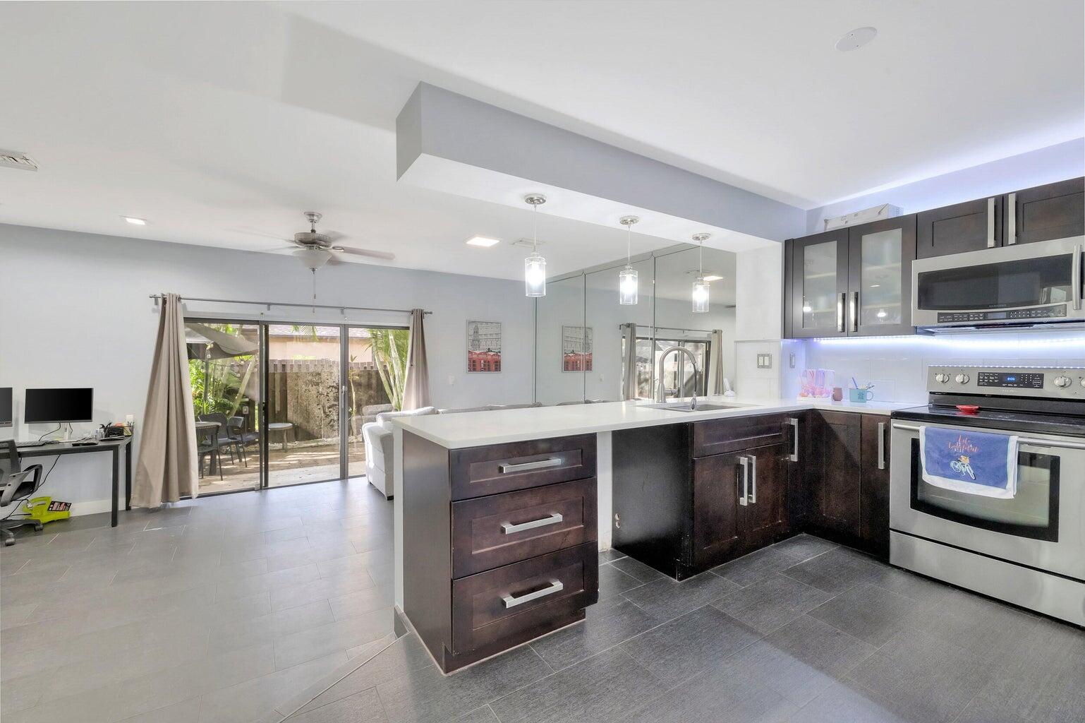 7610 Northwest 79th Avenue, Unit I5 Fort Lauderdale, FL 33321 - Photo 6 of 22 a kitchen with stainless steel appliances granite countertop a stove a sink and a microwave