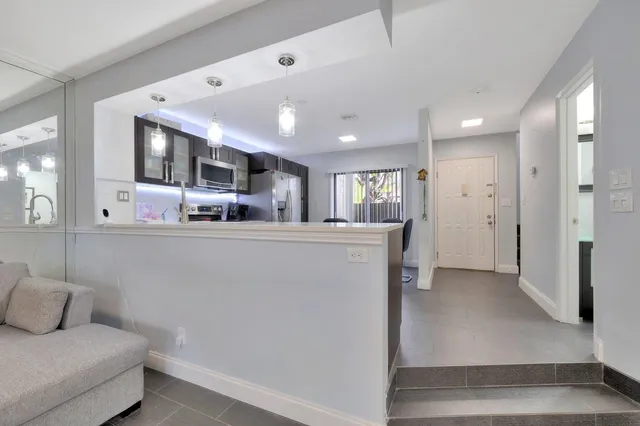 a living room with stainless steel appliances kitchen island granite countertop furniture and a view of kitchen