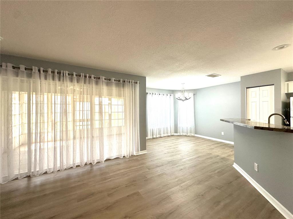 9706 Southwest 92nd Place Road Ocala, FL 34481 - Photo 5 of 82 a view of an empty room with a window and wooden floor