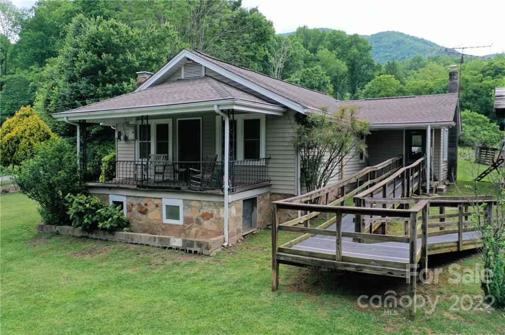 826 Monteith Branch Road Sylva, NC 28779 - Photo 1 of 14 a front view of house with a garden and swimming pool