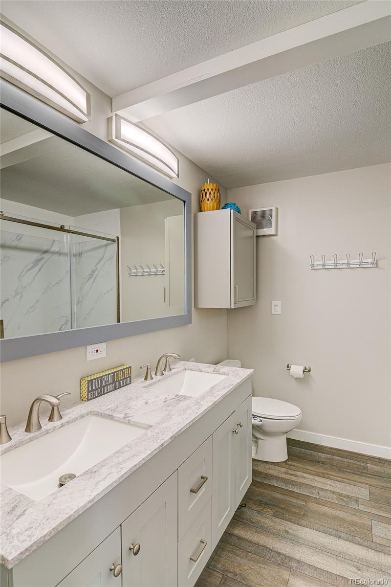 4531 East Best Road Larkspur, CO 80118 - Photo 23 of 49 a bathroom with a granite countertop sink mirror and toilet