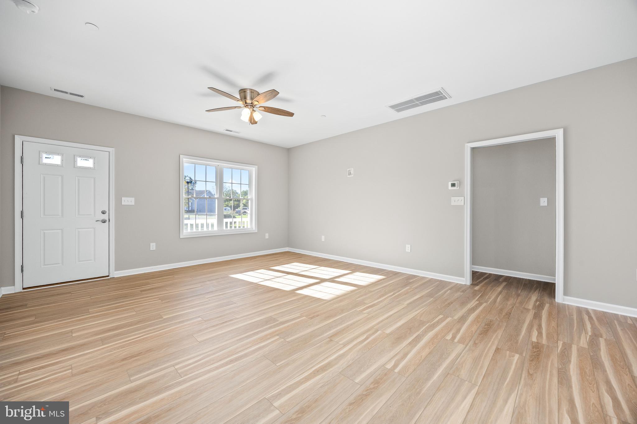 11779 St Stephens Way Princess Anne, MD 21853 - Photo 11 of 51 wooden floor in an empty room with a window