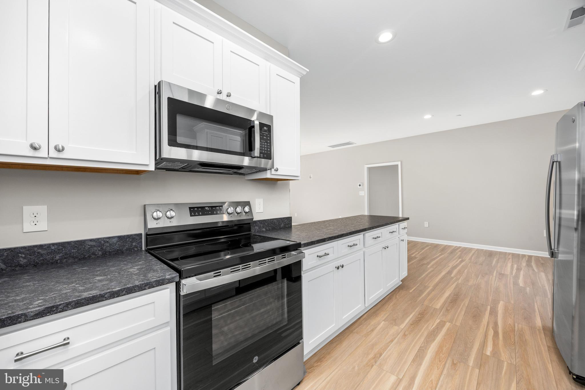 11779 St Stephens Way Princess Anne, MD 21853 - Photo 17 of 51 a kitchen with stainless steel appliances granite countertop a stove and a microwave