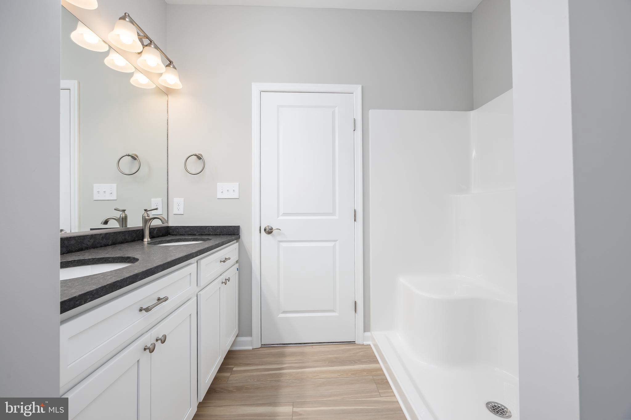 11779 St Stephens Way Princess Anne, MD 21853 - Photo 28 of 51 a spacious bathroom with a granite countertop sink and a mirror
