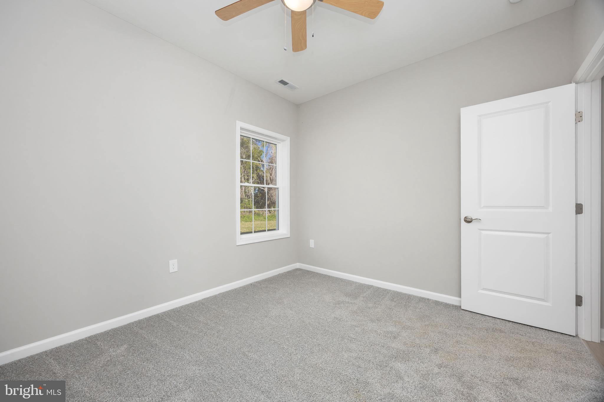 11779 St Stephens Way Princess Anne, MD 21853 - Photo 31 of 51 an empty room with chandelier fan and windows
