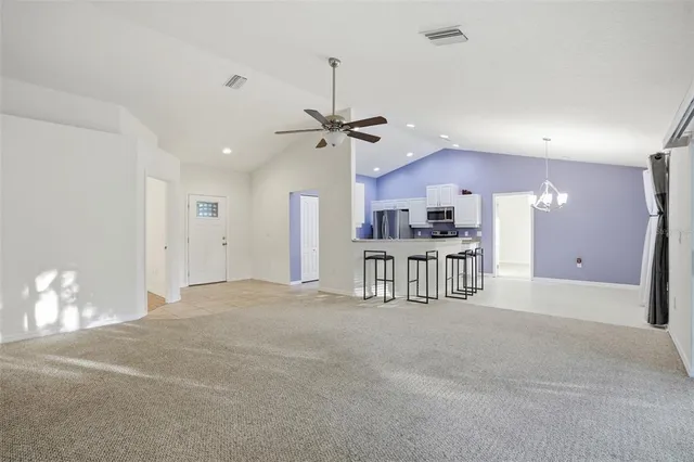an empty room with wooden floor chandelier fan and closet area