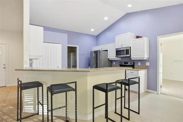 an empty room with a chandelier fan and windows