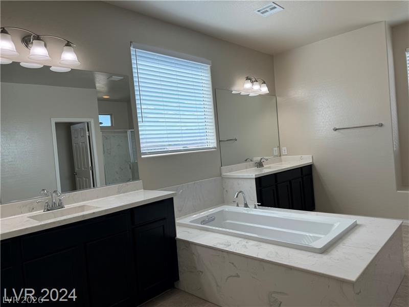 9056 Tony Ridge Avenue Las Vegas, NV 89148 - Photo 18 of 32 Indulge in a tranquil retreat with a deep soaking tub and dual vanities in this inviting primary bath.