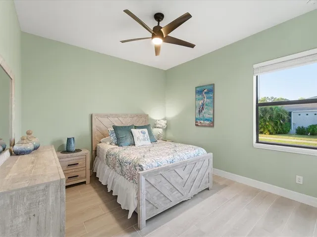 a view of a bedroom with wooden floor cabinet and mirror