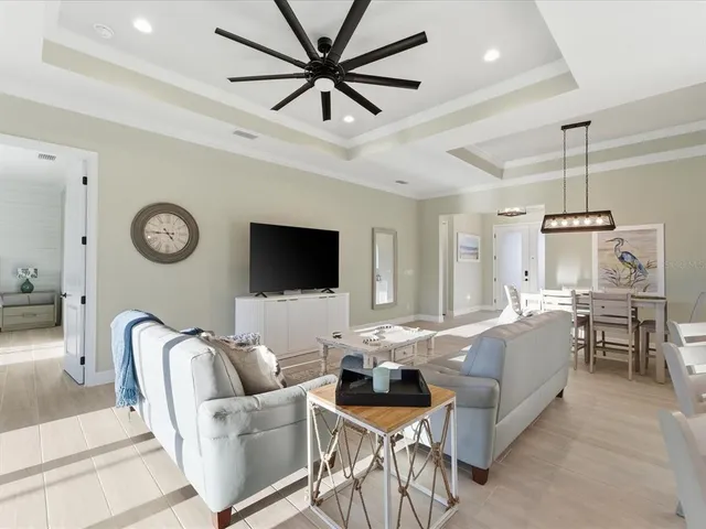a living room with furniture a clock and a ceiling fan