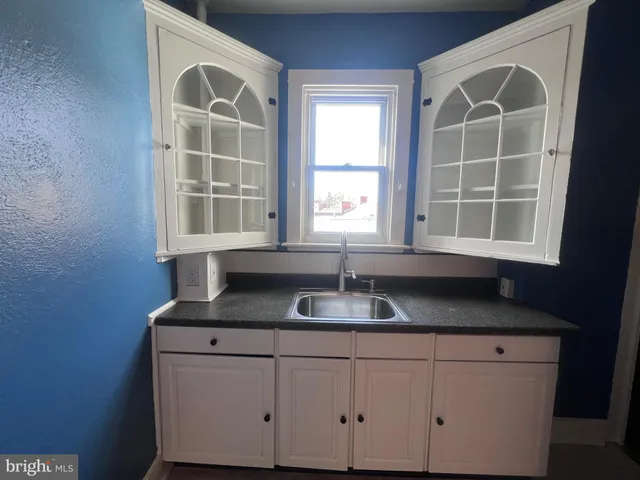 a kitchen with white cabinets and white appliances