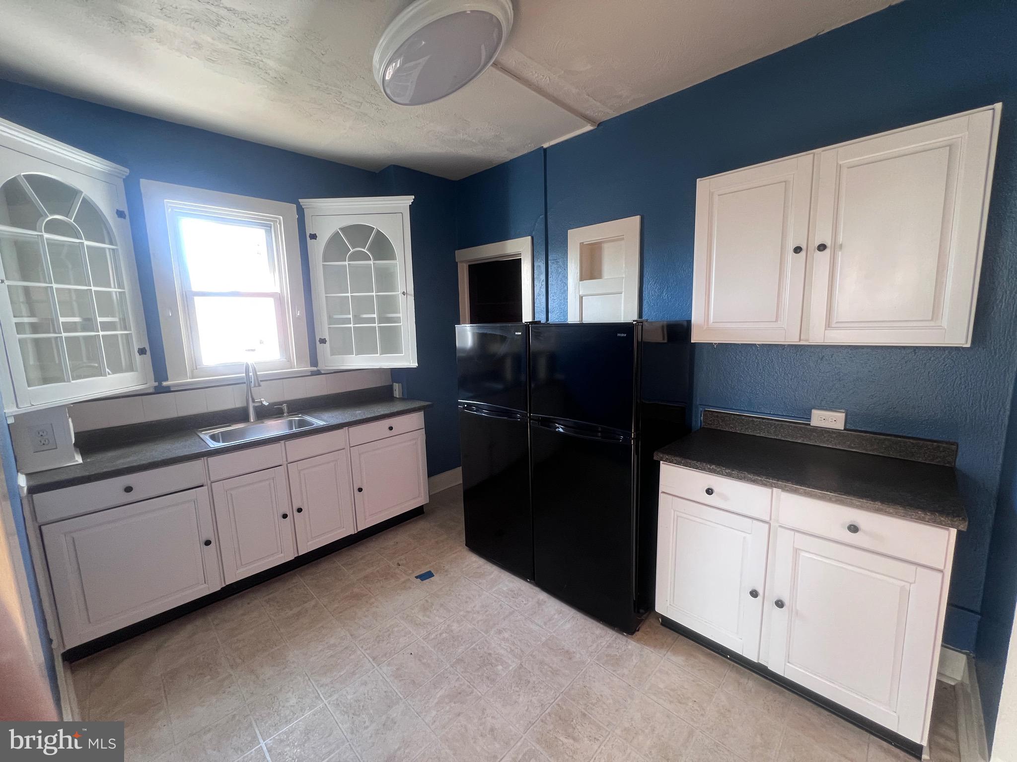 144 West Patrick Street, Unit 4 Frederick, MD 21701 - Photo 10 of 16 a kitchen with granite countertop white cabinets and black appliances