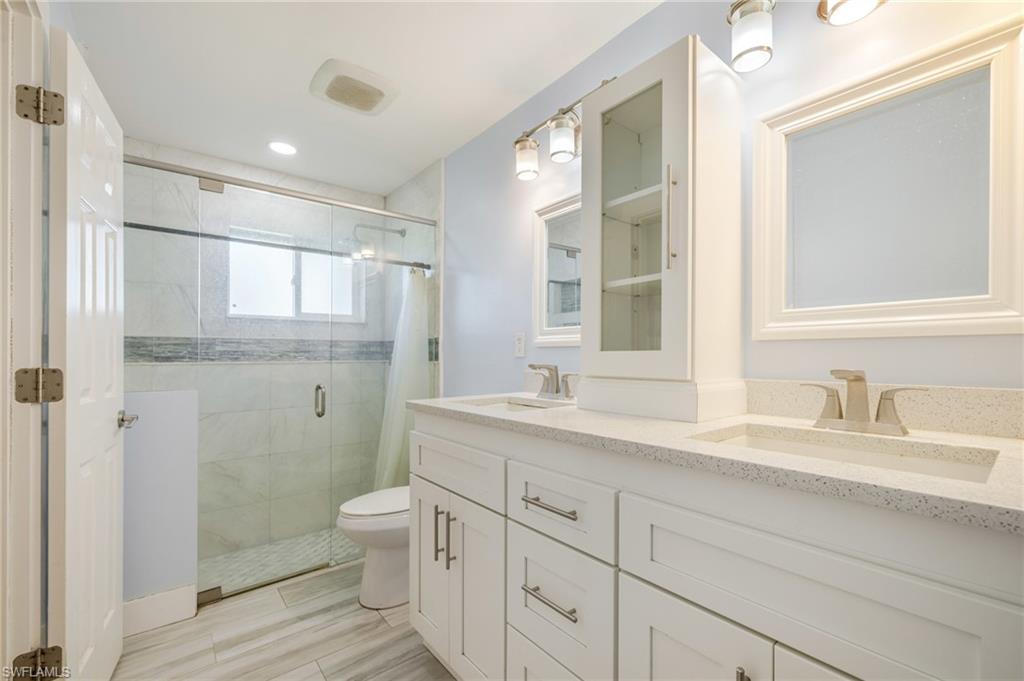 339 Beachwood Road Lehigh Acres, FL 33936 - Photo 12 of 32 Bathroom featuring a shower stall, double vanity, and recessed lighting