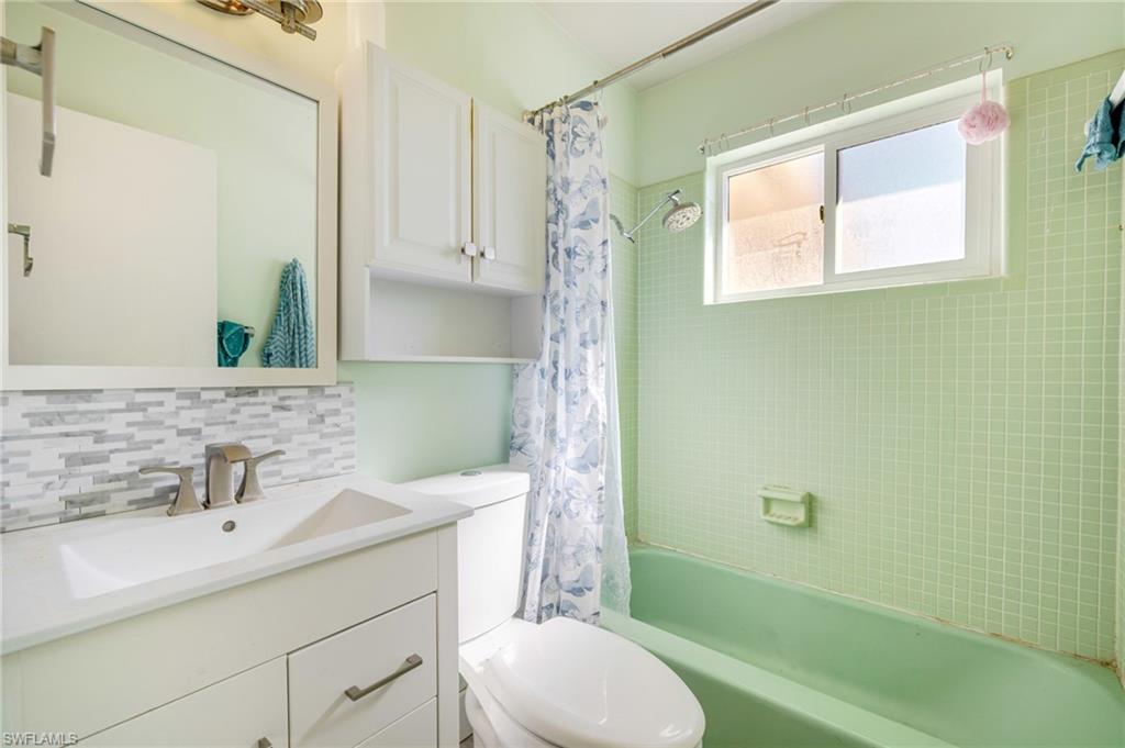 339 Beachwood Road Lehigh Acres, FL 33936 - Photo 14 of 32 Bathroom with shower / tub combo with curtain, vanity, and backsplash