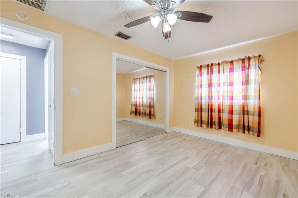 339 Beachwood Road Lehigh Acres, FL 33936 - Photo 17 of 32 Spare room featuring a ceiling fan, wood finished floors, and a textured ceiling