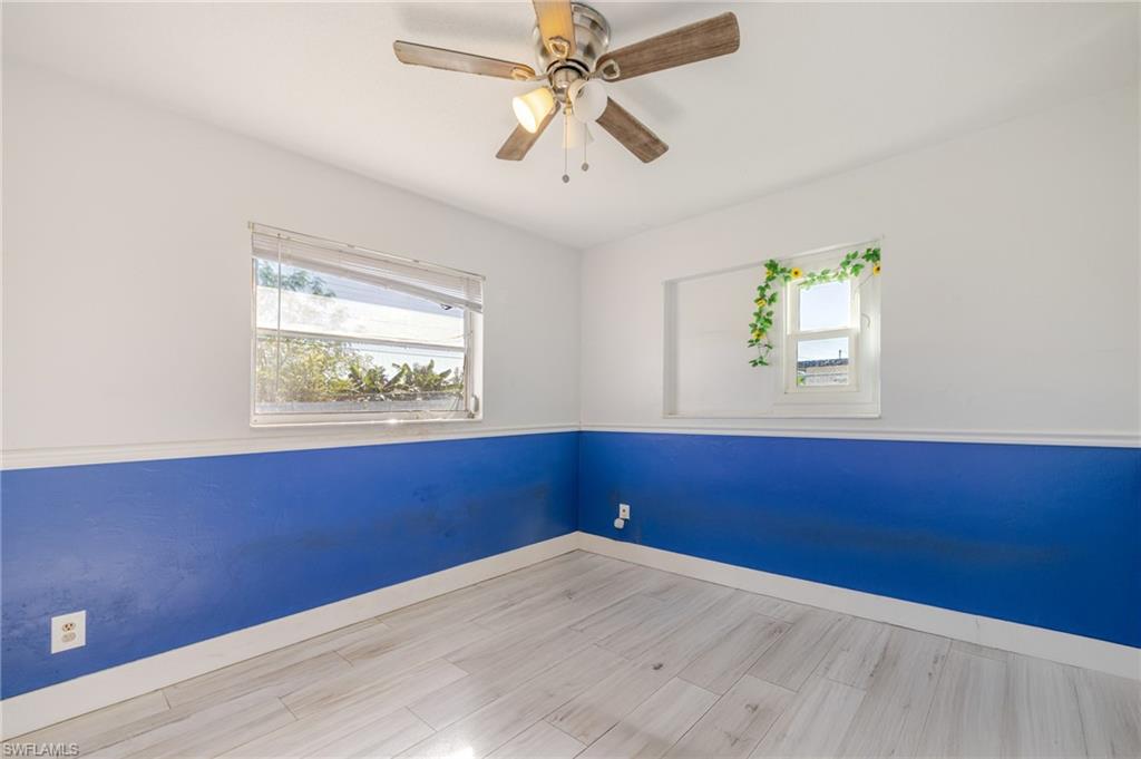 339 Beachwood Road Lehigh Acres, FL 33936 - Photo 18 of 32 Empty room featuring light wood-style flooring, healthy amount of natural light, and a ceiling fan