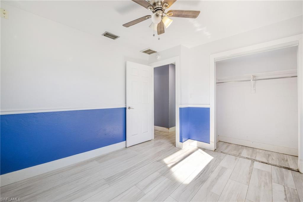 339 Beachwood Road Lehigh Acres, FL 33936 - Photo 19 of 32 Unfurnished bedroom with ceiling fan, wood finished floors, and a closet