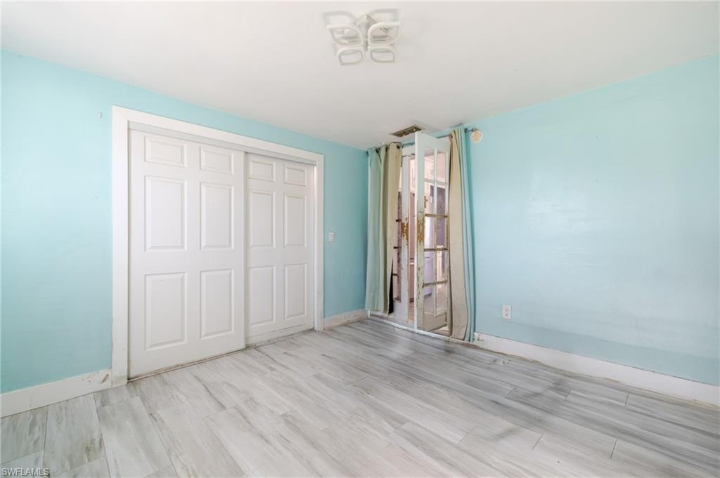339 Beachwood Road Lehigh Acres, FL 33936 - Photo 21 of 32 Unfurnished bedroom featuring wood finished floors and a closet