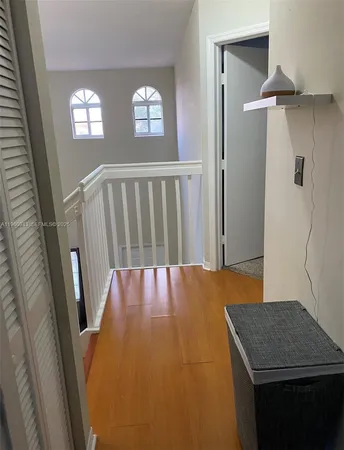 a view of a hallway to a livingroom with furniture