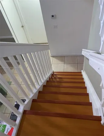 a walk in closet with wooden floor