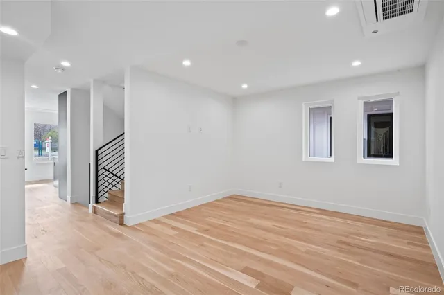 an empty room with wooden floor and hallway