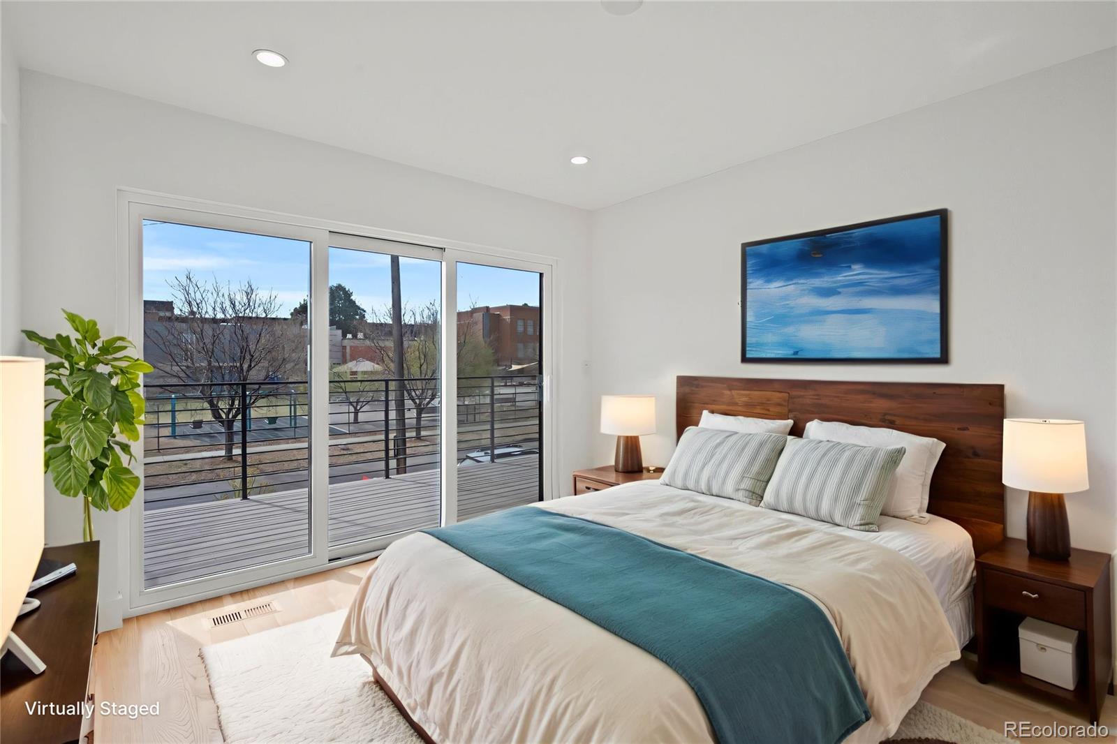 2453 Lawrence Street, Unit 1 Denver, CO 80205 - Photo 5 of 48 a bedroom with a balcony a bed and a painting on the wall