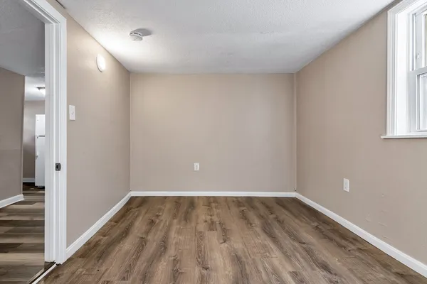 a view of a room with wooden floor and a window