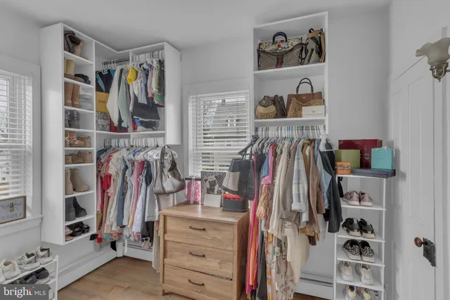 a view of walk in closet with clothes and shoes