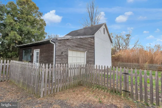 a view of a brick house with wooden fence