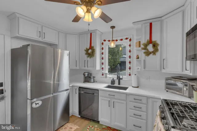 a kitchen with stainless steel appliances white cabinets and white appliances
