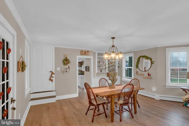 a dining room with furniture a chandelier and wooden floor