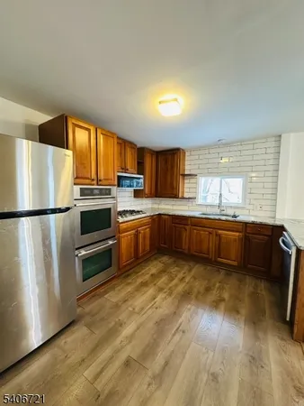 a kitchen with stainless steel appliances granite countertop a sink stove and cabinets
