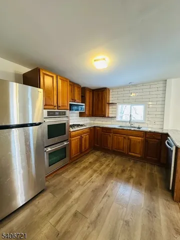 a kitchen with stainless steel appliances granite countertop a sink stove and cabinets