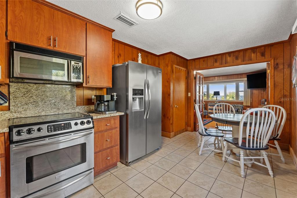 3461 Gum Drive Weeki Wachee, FL 34607 - Photo 25 of 48 a kitchen with stainless steel appliances granite countertop a stove top oven a sink and a refrigerator