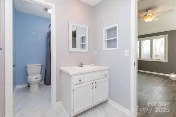 a spacious bathroom with a toilet sink and mirror