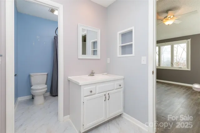a spacious bathroom with a toilet sink and mirror