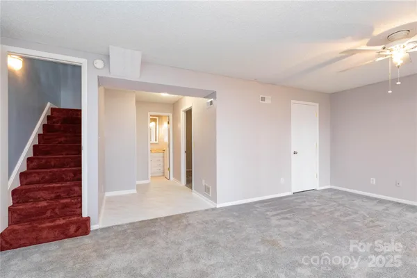 a view of a hallway with stairs and wooden floor