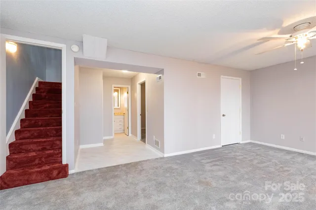 a view of a hallway with stairs and wooden floor