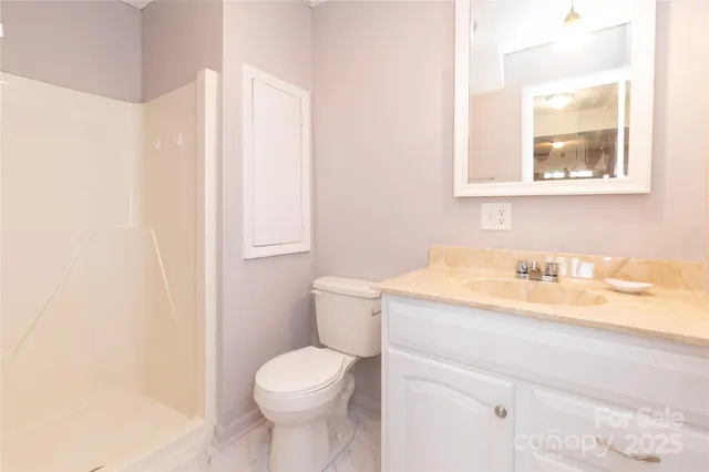a bathroom with a granite countertop sink toilet and a mirror