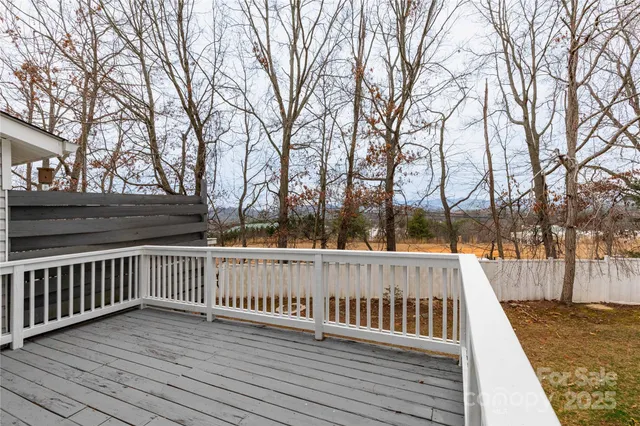 a view of deck with wooden fence and trees