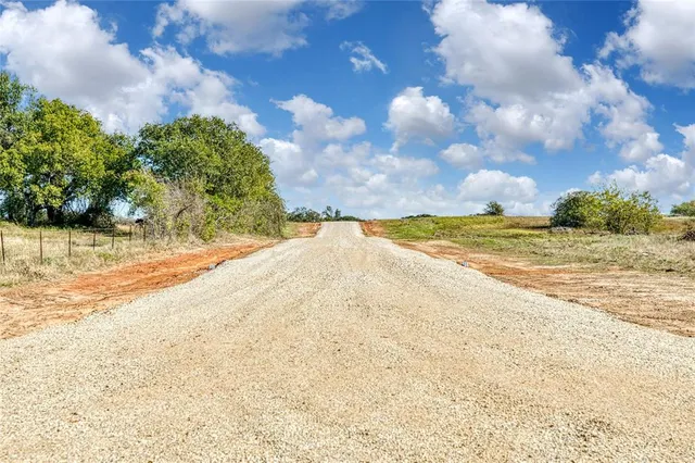 a sign that is sitting in the grass near an outdoor space